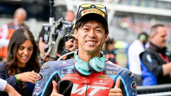 El piloto Ai Ogura sonríe y levanta los pulgares en el paddock