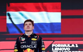 Max Verstappen en el podio junto a la bandera de los Países Bajos.