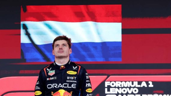 Max Verstappen en el podio junto a la bandera de los Países Bajos.