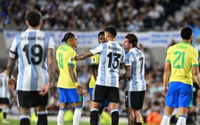 Raphinha y De Paul hablan durante el partido.