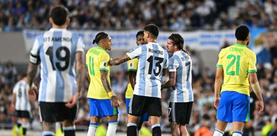 Raphinha y De Paul hablan durante el partido.