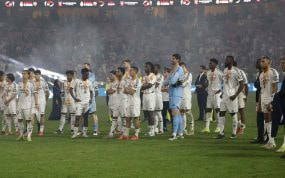 Los jugadores del Real Madrid ven como el Barcelona levanta la Supercopa.