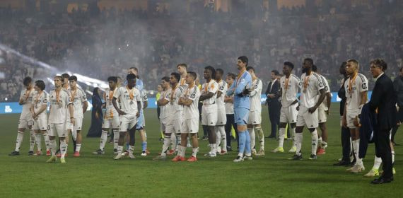 Los jugadores del Real Madrid ven como el Barcelona levanta la Supercopa.