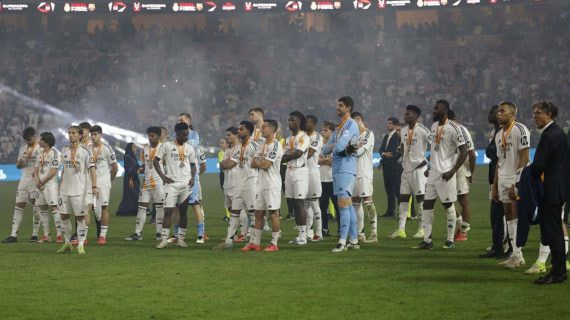 Los jugadores del Real Madrid ven como el Barcelona levanta la Supercopa.