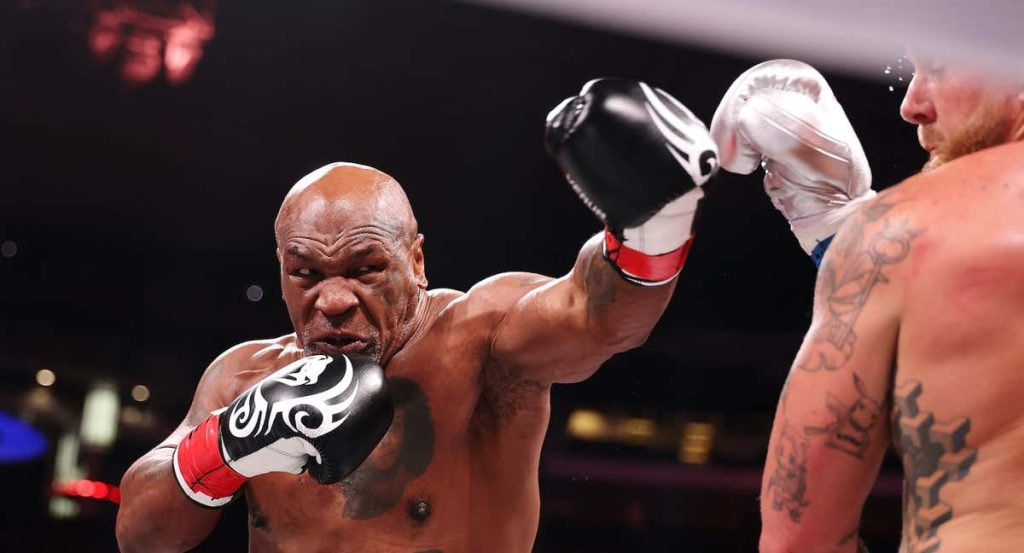 Mike Tyson lanza un golpe contra Jake Paul.