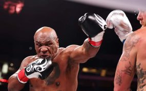 Mike Tyson lanza un golpe contra Jake Paul.