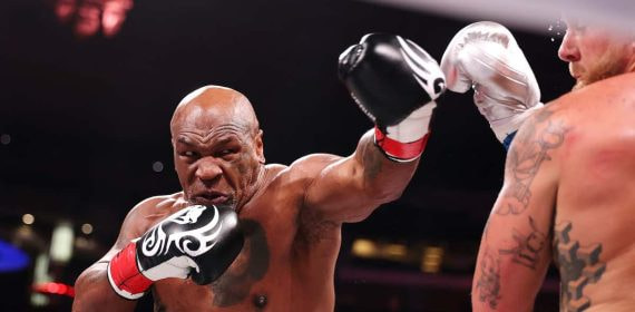 Mike Tyson lanza un golpe contra Jake Paul.