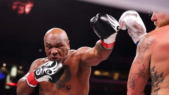 Mike Tyson lanza un golpe contra Jake Paul.