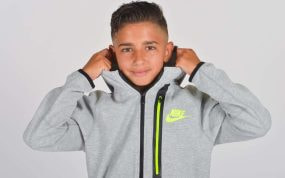 Yeremay, con 13 años de edad, posa sonriente con su nueva sudadera