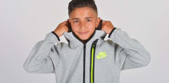 Yeremay, con 13 años de edad, posa sonriente con su nueva sudadera