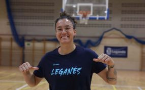 Laura Nicholls sonríe señalando la camiseta del Baloncesto Leganés en el pabellón