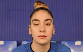 Primer plano de Paula Saravia, con moño y camiseta azul, mirando a cámara