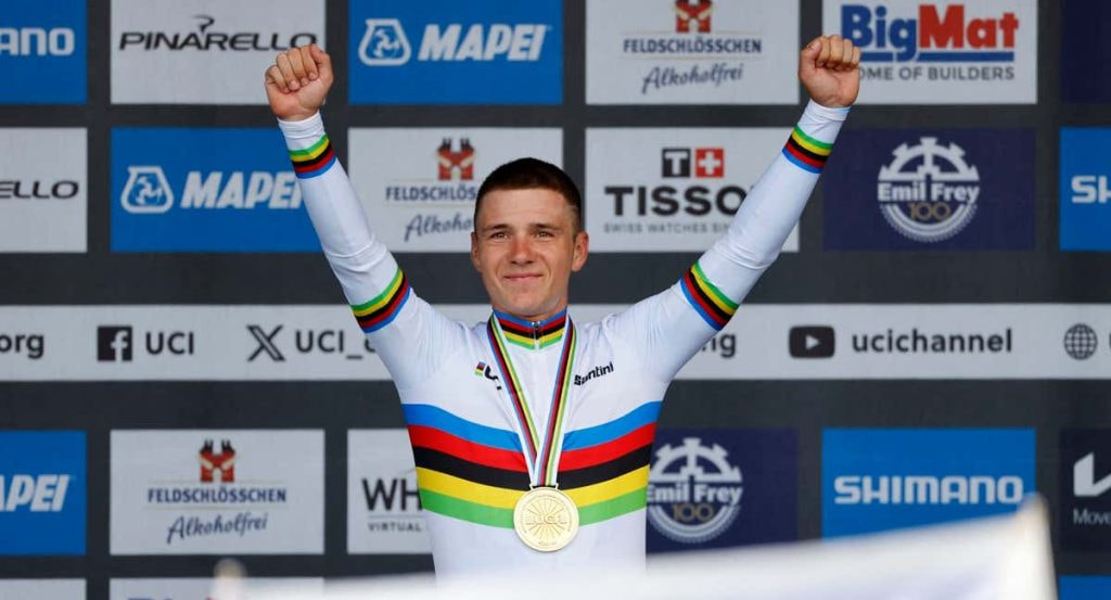 Remco Evenepoel levanta los brazos en el podio con el maillot arcoíris y la medalla de oro de campeón del mundo