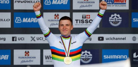 Remco Evenepoel levanta los brazos en el podio con el maillot arcoíris y la medalla de oro de campeón del mundo