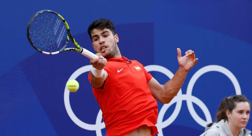 Carlos Alcaraz golpea una derecha sobre tierra batida con la camiseta roja de España en los Juegos Olímpicos de París