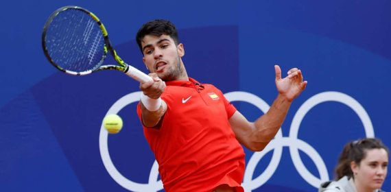Carlos Alcaraz golpea una derecha sobre tierra batida con la camiseta roja de España en los Juegos Olímpicos de París