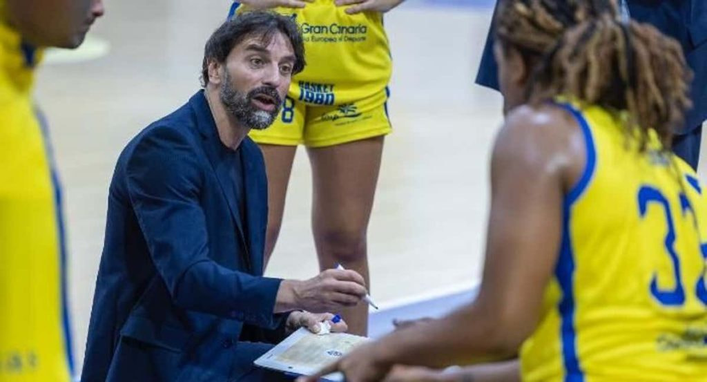 César Aneas da instrucciones con la pizarra a las jugadoras del Spar Gran Canaria durante un tiempo muerto