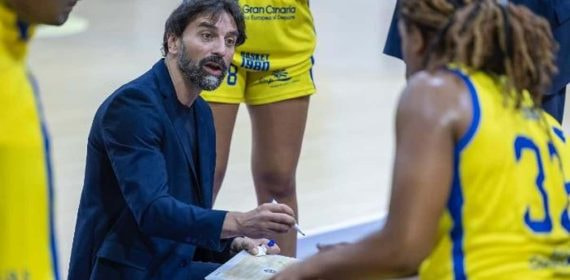 César Aneas da instrucciones con la pizarra a las jugadoras del Spar Gran Canaria durante un tiempo muerto