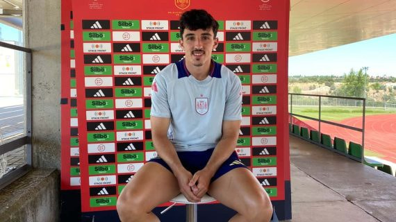 Diego López, sentado ante un photocall de la selección española junto a la pista de atletismo