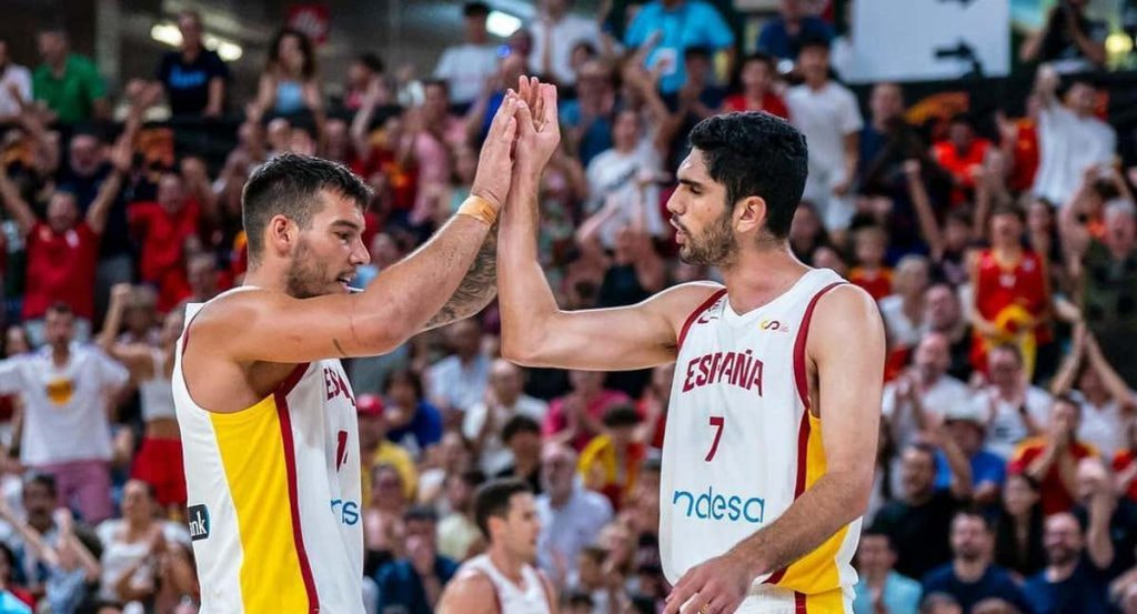 Willy Hernangómez y Santi Aldama chocan las manos con la camiseta blanca de España