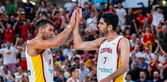 Willy Hernangómez y Santi Aldama chocan las manos con la camiseta blanca de España