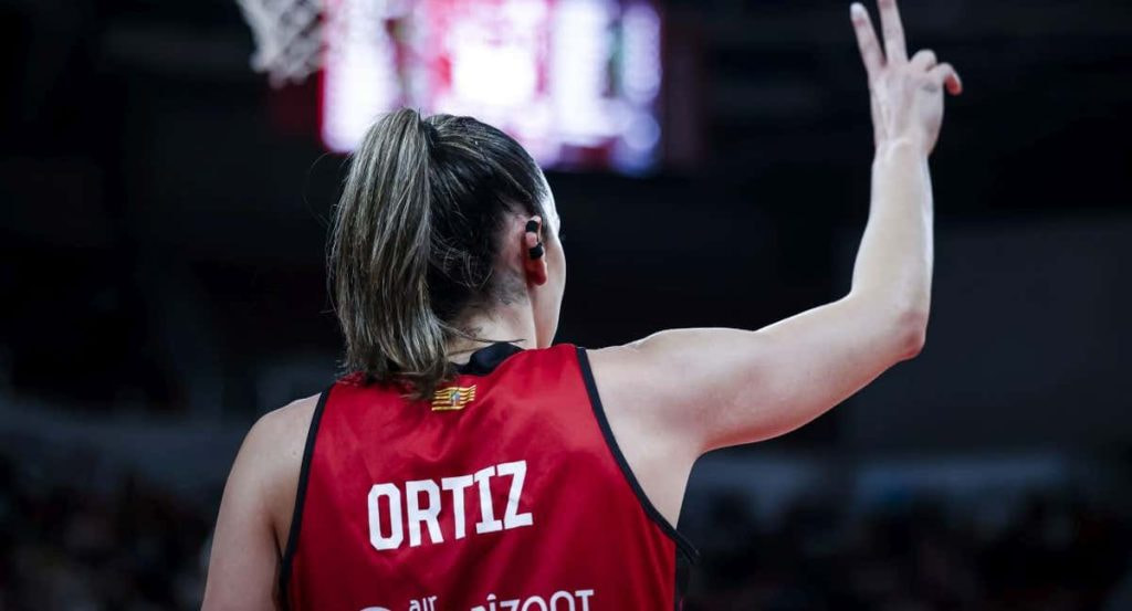 Mariona Ortiz, de espaldas con su camiseta roja, señala una jugada con la mano en alto