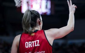 Mariona Ortiz, de espaldas con su camiseta roja, señala una jugada con la mano en alto