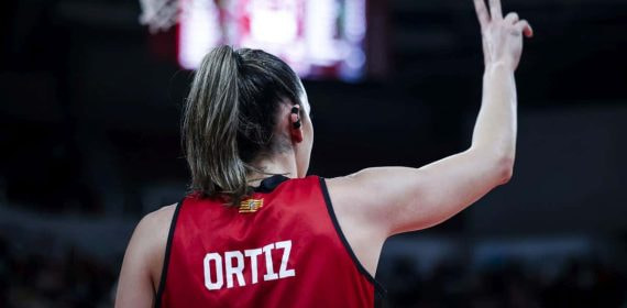 Mariona Ortiz, de espaldas con su camiseta roja, señala una jugada con la mano en alto
