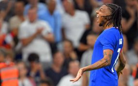 Michael Olise grita para celebrar un gol con la camiseta azul de Francia