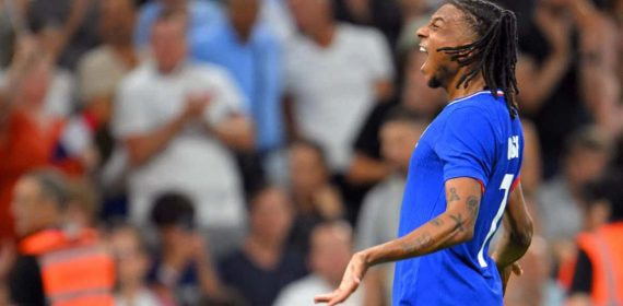 Michael Olise grita para celebrar un gol con la camiseta azul de Francia