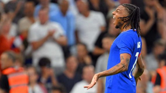 Michael Olise grita para celebrar un gol con la camiseta azul de Francia