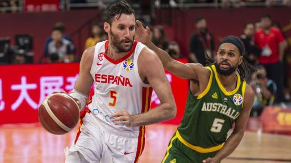Rudy Fernández conduce el balón con España perseguido por Patty Mills, con el 5 de Australia