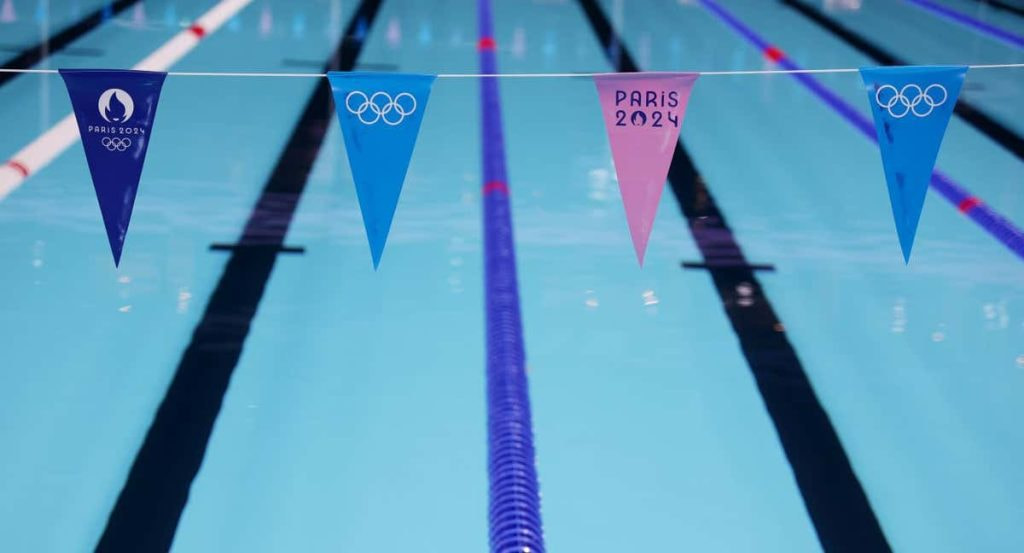 Calles vacías de la piscina olímpica de París 2024 con los banderines de los Juegos en primer plano