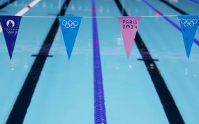 Calles vacías de la piscina olímpica de París 2024 con los banderines de los Juegos en primer plano