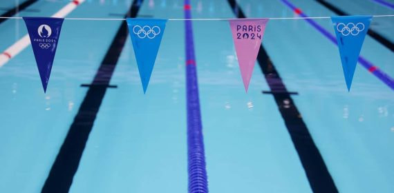 Calles vacías de la piscina olímpica de París 2024 con los banderines de los Juegos en primer plano