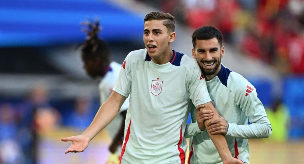 Fermín López gesticula junto a un compañero durante el calentamiento de la selección española en los Juegos