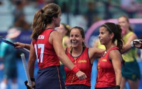 Tres jugadoras de la selección española de hockey hierba se abrazan sonrientes tras un gol ante Australia