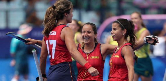 Tres jugadoras de la selección española de hockey hierba se abrazan sonrientes tras un gol ante Australia
