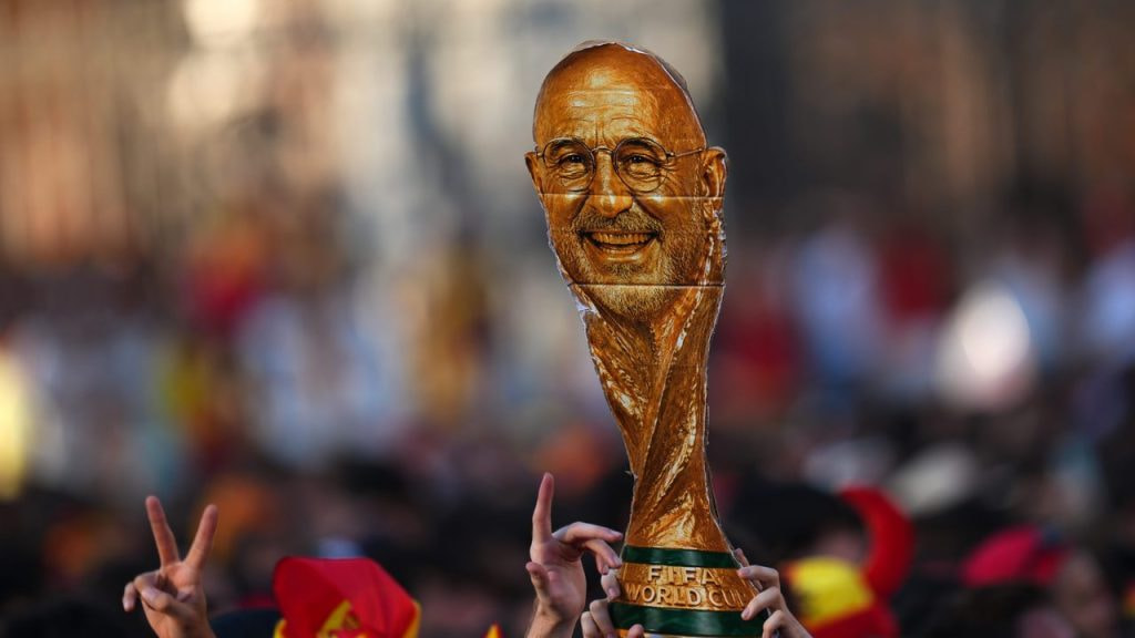 Celebración de los aficionados españoles con un trofeo de cartón con la forma de la Copa del Mundo y la cara de Luis de la Fuente.