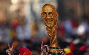 Celebración de los aficionados españoles con un trofeo de cartón con la forma de la Copa del Mundo y la cara de Luis de la Fuente.