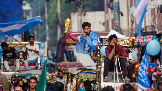 Un aficionado de Argentina sostiene una réplica de la Copa del Mundo en Dhaka, la capital de Bangladesh.