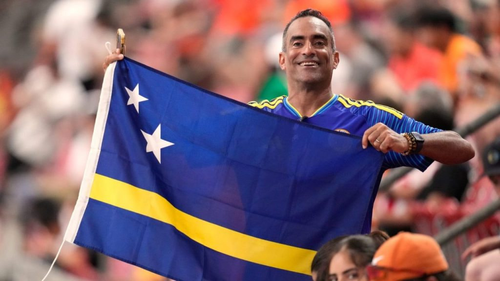 Un aficionado de Curazao con una bandera del país, en las gradas de un estadio del Mundial 2026.