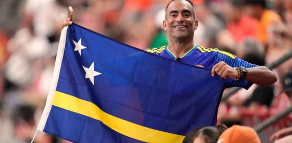 Un aficionado de Curazao con una bandera del país, en las gradas de un estadio del Mundial 2026.
