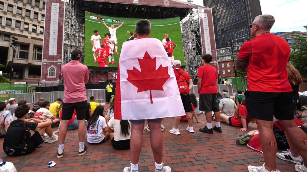Aficionados canadienses viendo a su selección en una pantalla gigante situada en las calles de Boston.