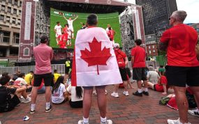 Aficionados canadienses viendo a su selección en una pantalla gigante situada en las calles de Boston.