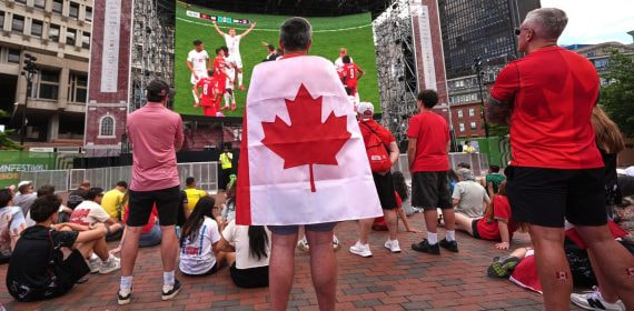Aficionados canadienses viendo a su selección en una pantalla gigante situada en las calles de Boston.