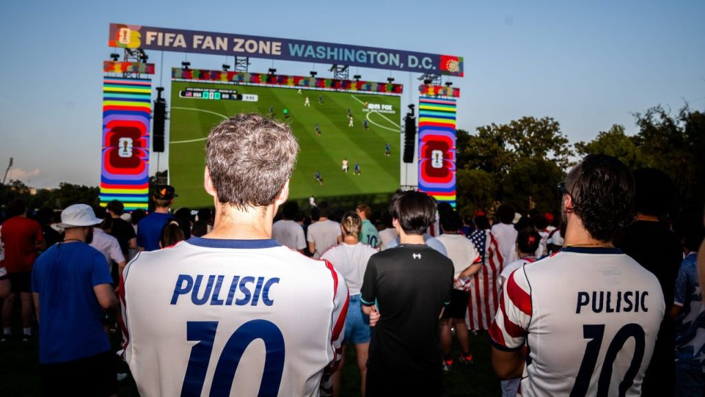 Dos aficionados de Estados Unidos ven un partido de su selección en el Mundial 2026 desde la fan zone de Washington.