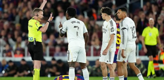 El árbitro español Alejandro Hernández Hernández saca una tarjeta amarilla durante un Clásico.