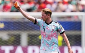 Kevin de Bruyne ofrece el brazalete de capitán antes de ser sustituido en el partido ante España.