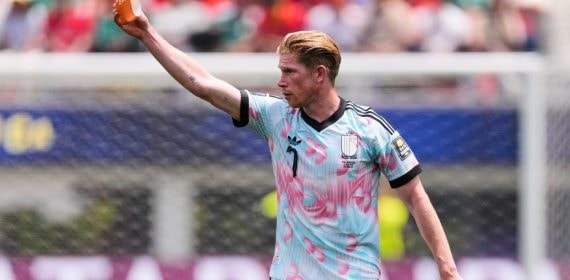 Kevin de Bruyne ofrece el brazalete de capitán antes de ser sustituido en el partido ante España.